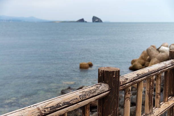 istock wooden railing and rocks on the sea 2251167591