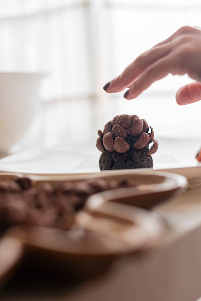 A Dramatic, Close Up Shot of a Trio of Chocolate Desserts: Chocolate Cake and Bon-Bons Served on an Orange Plate