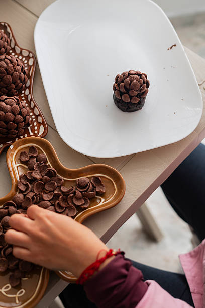 A pastry chef creates beautiful chocolate pineapples to decorate a client's Christmas dinner, meticulously adding every detail to her finished product.