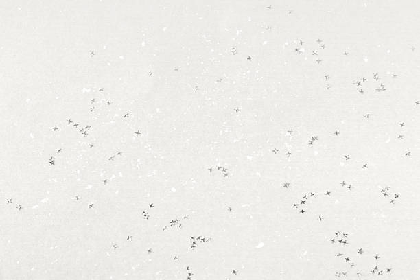 Demonstrating the colors of 2026 - Cloud Dancer. Gray white glitter confetti stars background. Color concept.