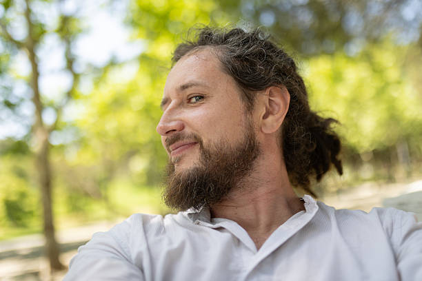 istock Man smiling outdoors enjoying natural park environment 2251178077