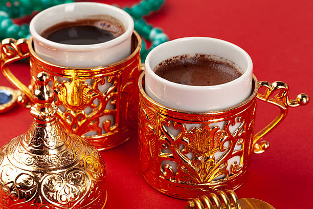 istock Turkish coffee in a golden oriental cup on red background 2251179412