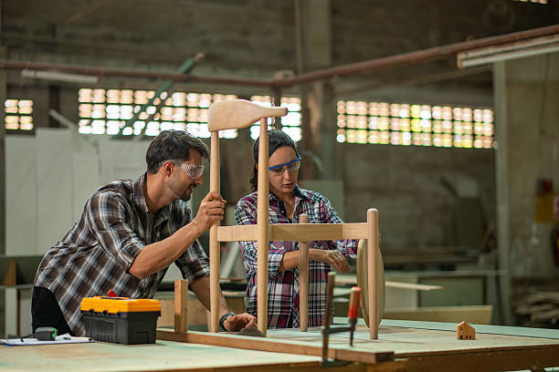 istock Carpenter workers collaborate reviewing plans and discussing project details clipboard and laptop focus on measurements and construction tasks craftsmanship in a professional industrial setting. 2251181209