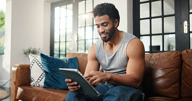istock Relax, scroll or man with tablet on couch, check social media or browsing movie selection on website. Subscription service, film and person chilling in home with tech, watch video or streaming choice 2251182248