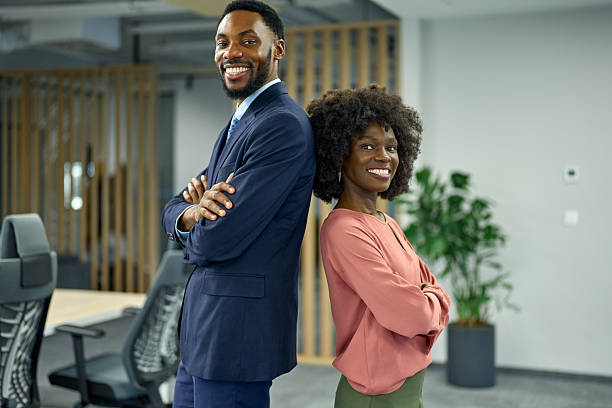istock Young professionals smiling standing back to back in office 2251188623