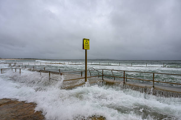 Waves crashing over an ocean swimming pool at high tide