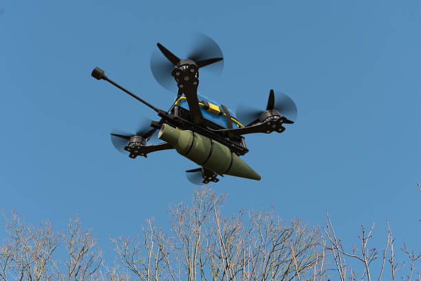 istock A combat drone flies over the trees, carrying suspended ammunition on a sling. 2251193737