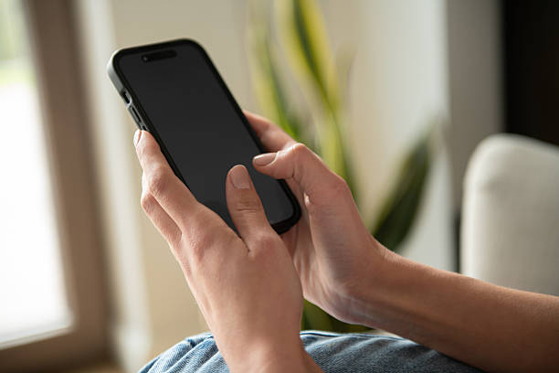 istock Smartphone in Hands Closeup Home Interior Background – Mobile Technology 2251194564