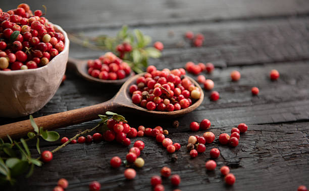 istock Assorted Lingonberries with Wooden Spoons on black burn background 2251195124