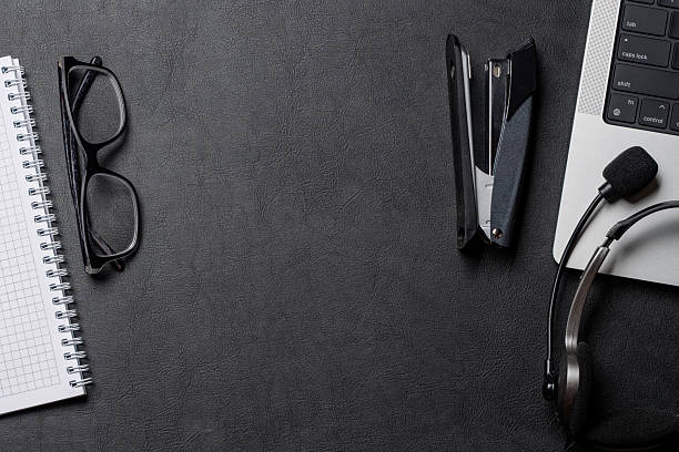 istock Office supplies and laptop on black leather workspace, top view with copy space 2251196604