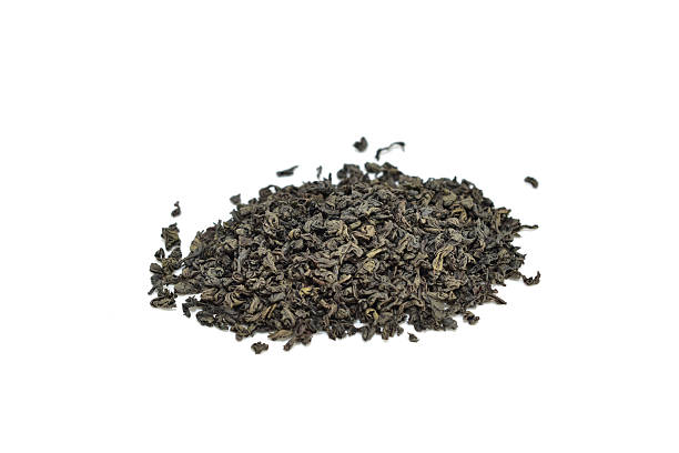 A pile of dry black tea leaves isolated on white background.