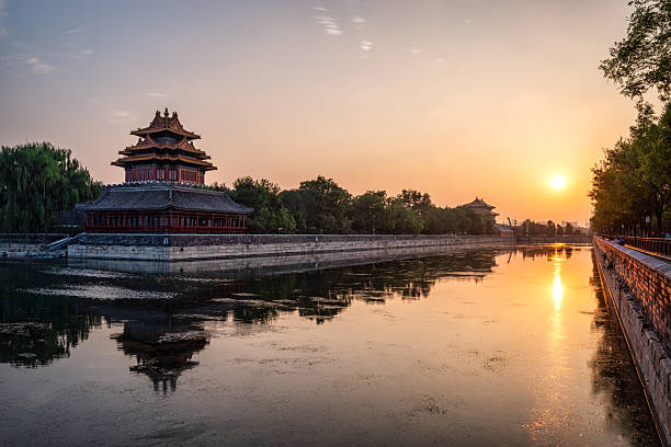 istock Forbidden City's imperial corner tower creating a perfect reflection on the surrounding moat water, illuminated by the warm glow of a golden sunset in Beijing 2251200376
