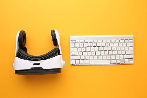 istock Virtual reality headset, keyboard and game controller on orange background  modern gaming and tech concept 2251202354