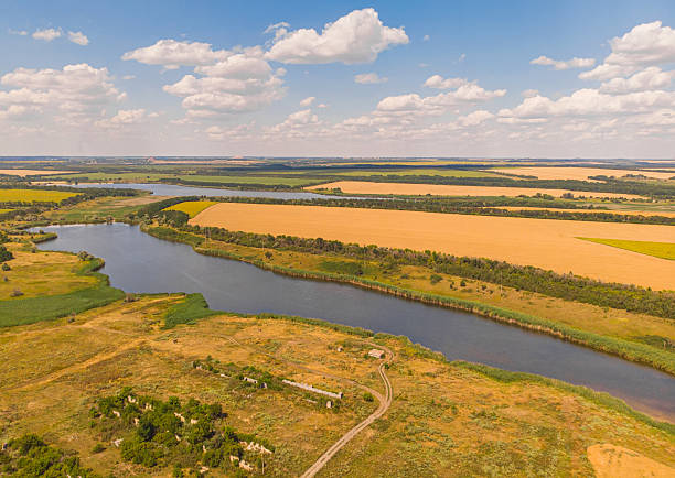 istock Beautiful view to the wheat fields with river and forest 2251209872