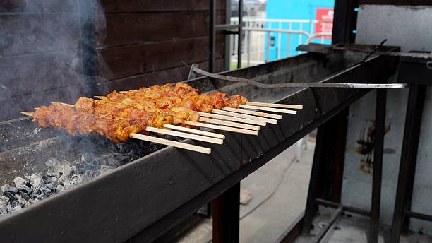 Barbecue smoke rising, Vendors cooking with fragrant smoke billowing, Festive market scene with sizzling food on open flames, Crowd gathers around lively outdoor grill with smoky aroma and colorful
