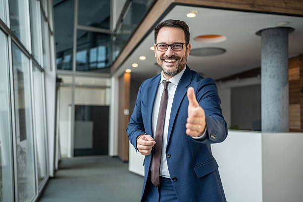 istock Smiling businessman offering handshake in modern office 2251214540