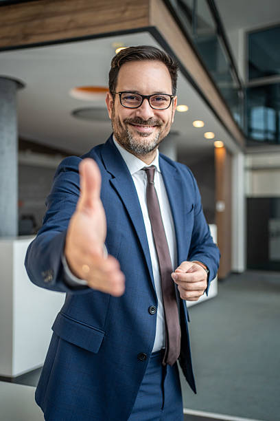 istock Businessman extending hand for handshake greeting in office 2251214684