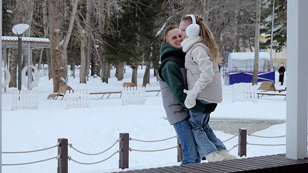 istock Caring father hugging young daughter during playful winter park outing, sharing warm embrace while snowflakes drift around cheerful family moment 2251214716