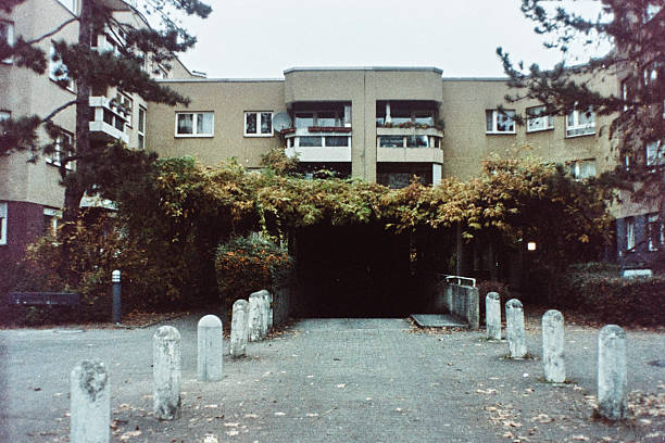 Quiet Apartment Complex Entrance Surrounded By Autumn Trees And Concrete Bollards In Moabit, Berlin. Colour film photography. Scan from a negative.