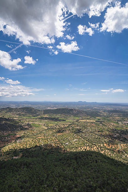 Stunning aerial view of rural landscape with green fields and mountains in the background.
