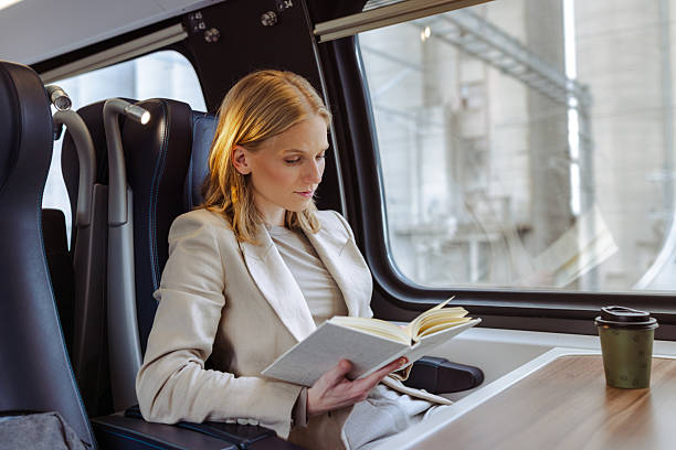 istock Business traveler reading a notebook on a train with coffee cup nearby 2251222484