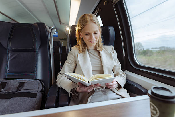 istock Professional woman on a train reading a book during a commute, focused and relaxed 2251222832