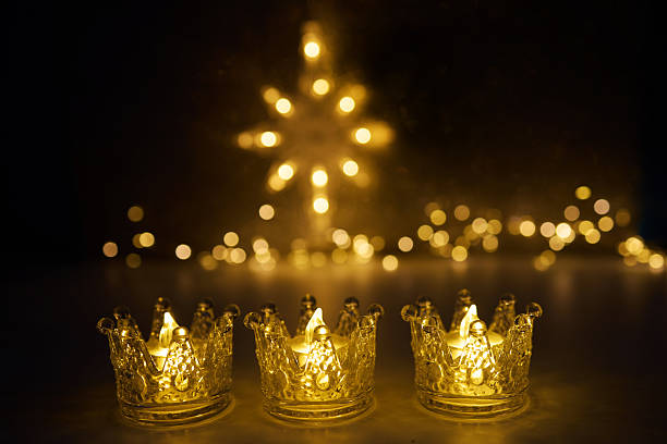 istock Candlelit Starry Night. Three ornate candles glow with a star-shaped light backdrop 2251222868