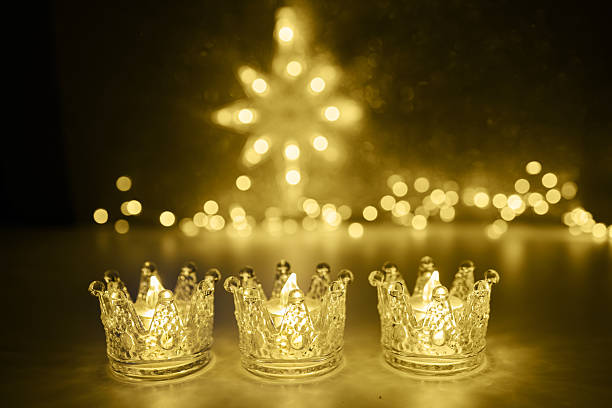 istock Candlelit Starry Night. Three ornate candles glow with a star-shaped light backdrop 2251222898