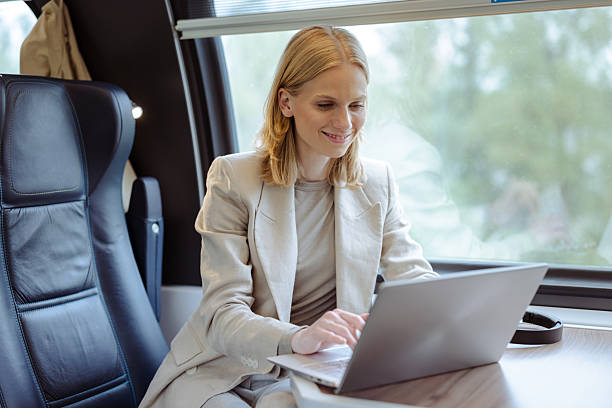 istock Businesswoman traveling by train using laptop and smiling during commute in a modern setting 2251222944