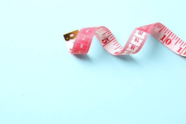 istock Red tape measure on a color background, top view 2251224836