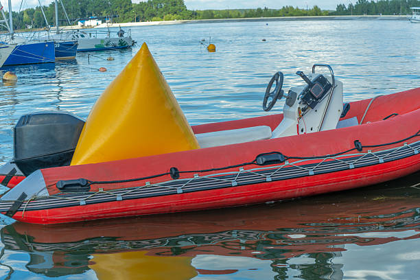 Inflatable rescue boat equipped with steering console. Safe haven for exploration a red inflatable boat rests peacefully at the pier ready to embark on new adventures.