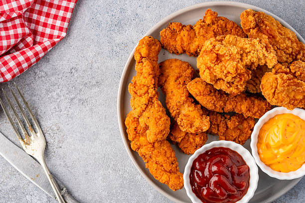 istock Fried chicken breast strips on grey table background. Delicious chicken crisps 2251227341