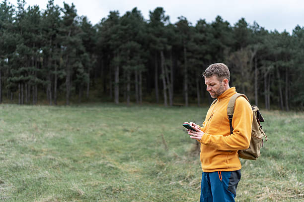 istock Man hiker using phone for navigation outdoors 2251227568
