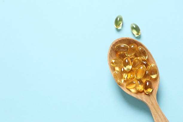 istock Fish oil tablets in wooden spoon. Biologically active additives. Omega 3, 6, omega 9, vitamin A, E, D 2251227730