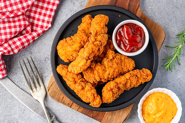 istock Fried chicken breast strips on grey table background. Delicious chicken crisps 2251228734
