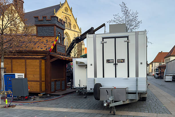 istock Workers set up a market stall with trailers in a town square 2251229077