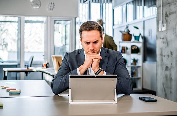 istock Businessman contemplating strategy using tablet in modern office 2251229145