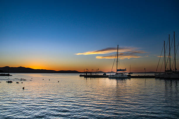 sailboats docked at a marina during sunrise or sunset