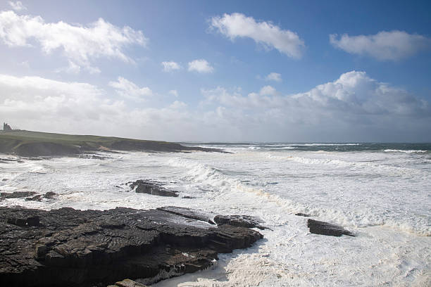 Rugged West coast of Ireland during storm Amy October 2025 with high waves and turbulent, foamy water seen rom Castle Classiebawn Viewpoint and white clouded blue sky