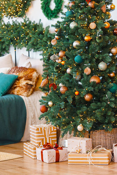 istock Christmas tree with gift boxes, presents in bedroom. Festive decorations with wrapped gifts near bed 2251229542
