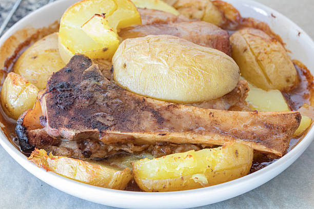 Pork knuckle and boiled potatoes with meat sauce.