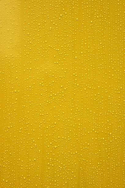 istock yellow background with water drops 2251230077