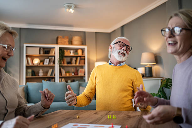 istock Senior friends enjoying board game at home, laughing 2251231201