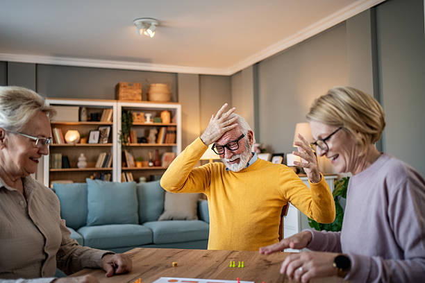 istock Senior friends playing board game laughing and having fun 2251231215