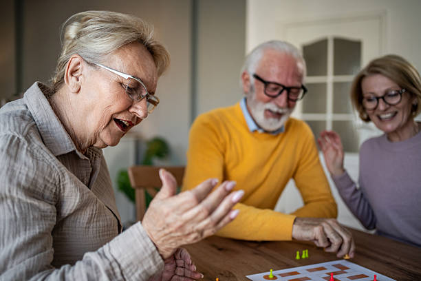 istock Senior friends enjoying leisure time playing board game 2251231250