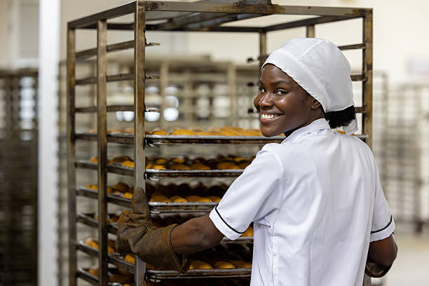 istock Happy baker moving fresh bread in a cart 2251231480