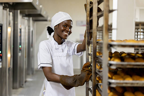 istock Happy employee working at a bakery moving fresh bread 2251231493