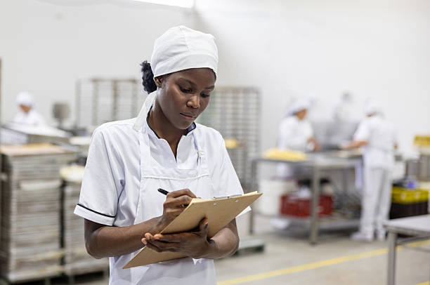 istock Employee writing on a clipboard while working at an industrial bakery 2251231545