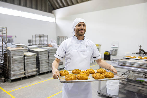 istock Baker carrying a tray of freshy baked bread 2251231571