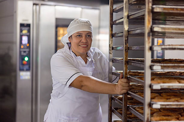 istock Woman working at a bakery and pushing a car with fresh bread 2251231594